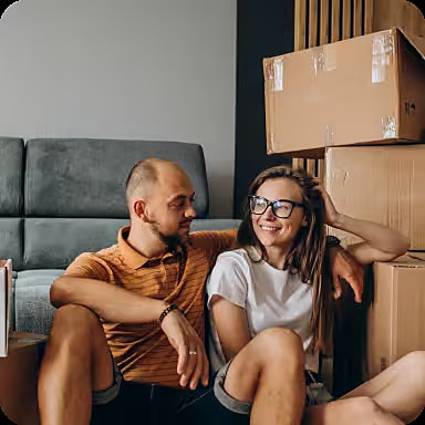 Couple installé au milieu de cartons de déménagement